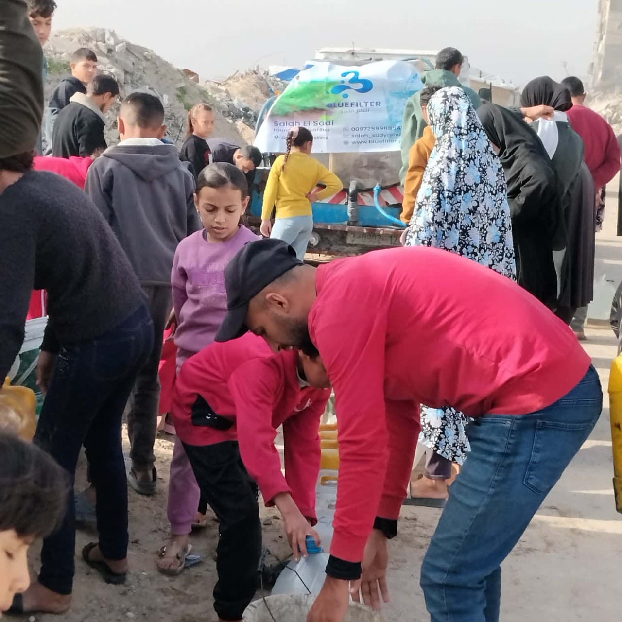 Families collecting drinking water from a Blue Filter distribution point